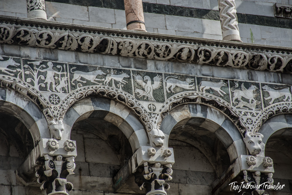 Intricate marble inlay friezes and arched arcades on the facade of San Michele in Foro, Lucca