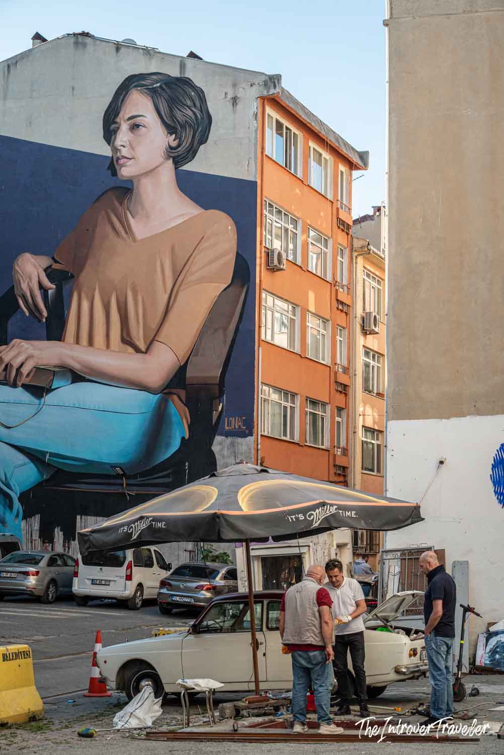 Large Lonac mural of a seated woman on a Kadıköy building wall, Istanbul street art festival
