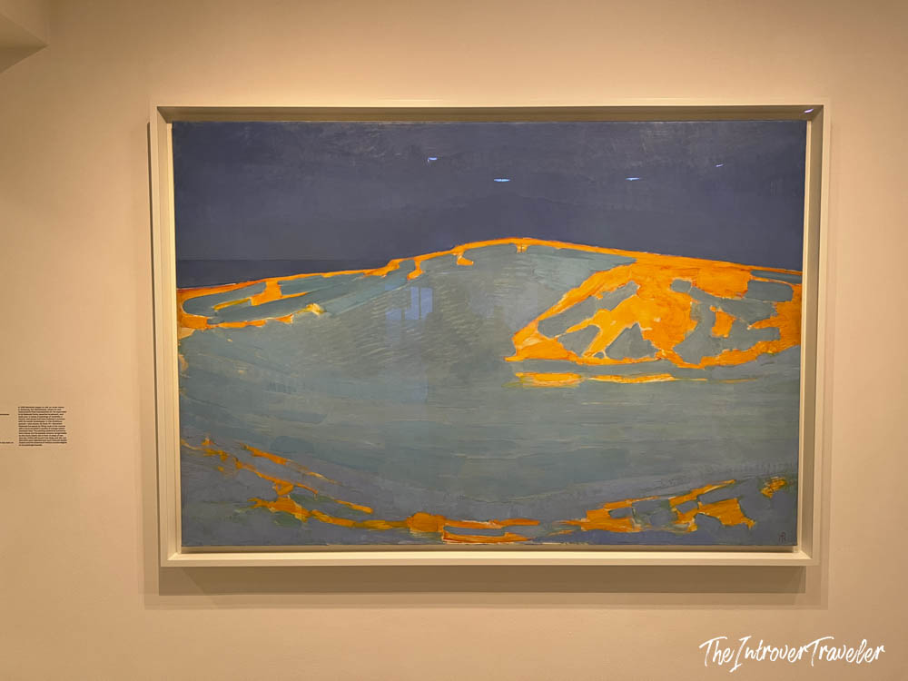 Abstract landscape painting with bold orange and blue tones, displayed on a gallery wall at the Guggenheim Museum New York