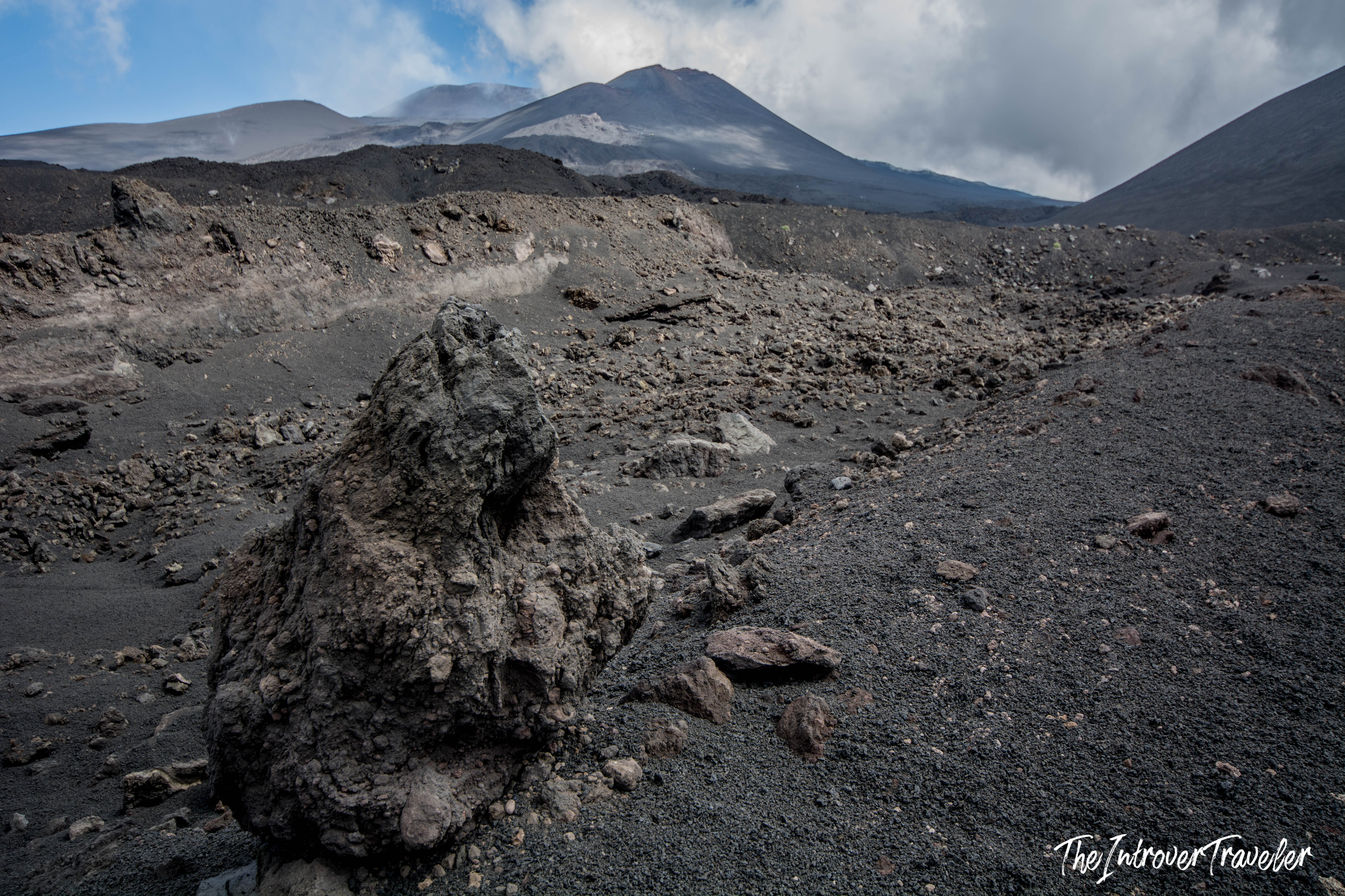 Lava rock and volcanic ash fields on Mount Etna, with the summit craters visible in the background
