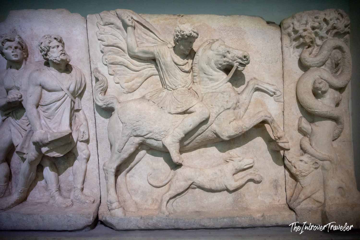Ancient marble relief at Istanbul Archaeological Museum showing a winged rider on horseback with serpent carvings