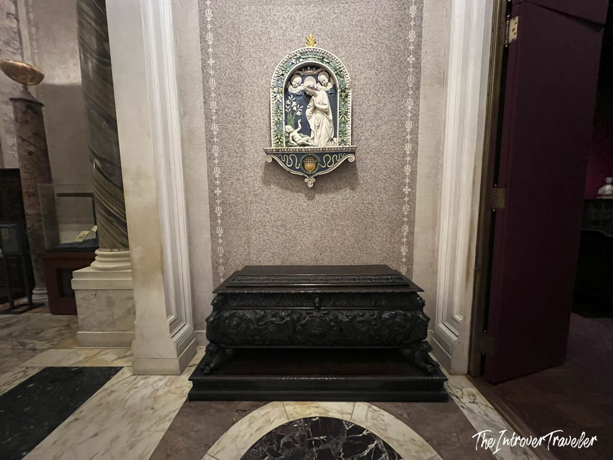 Ornate dark sarcophagus and glazed terracotta relief inside the Morgan Library and Museum, New York