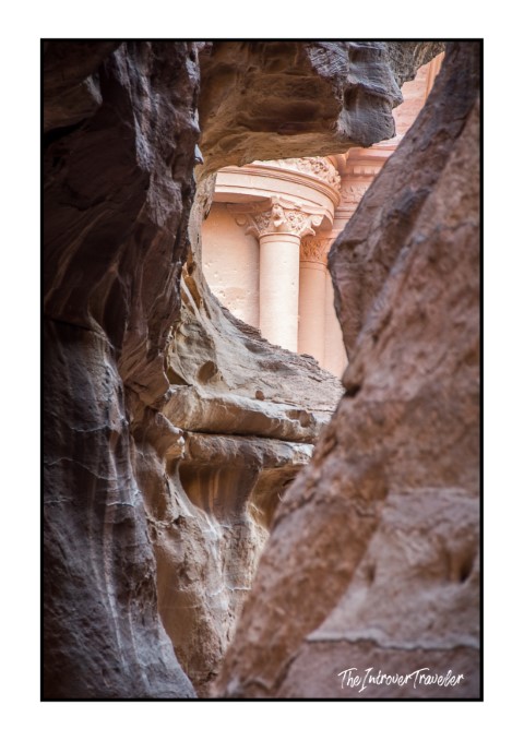 First glimpse of Al-Khazneh Treasury columns framed by the Siq canyon walls, Petra, Jordan