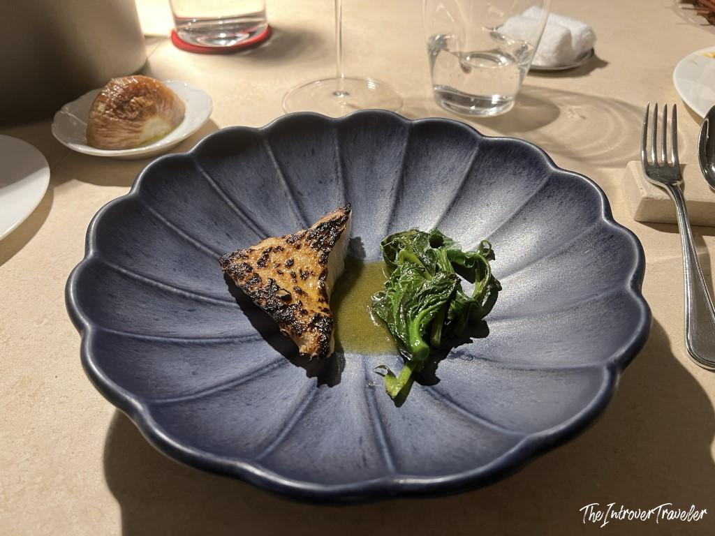 Charred fish fillet with sauteed greens in herb sauce, served at Trattoria Da Lucio, Rimini