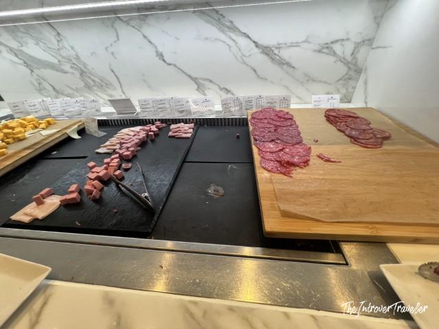 Sliced salami and diced cured meats on the charcuterie board at Pau Casals Lounge, Barcelona Airport