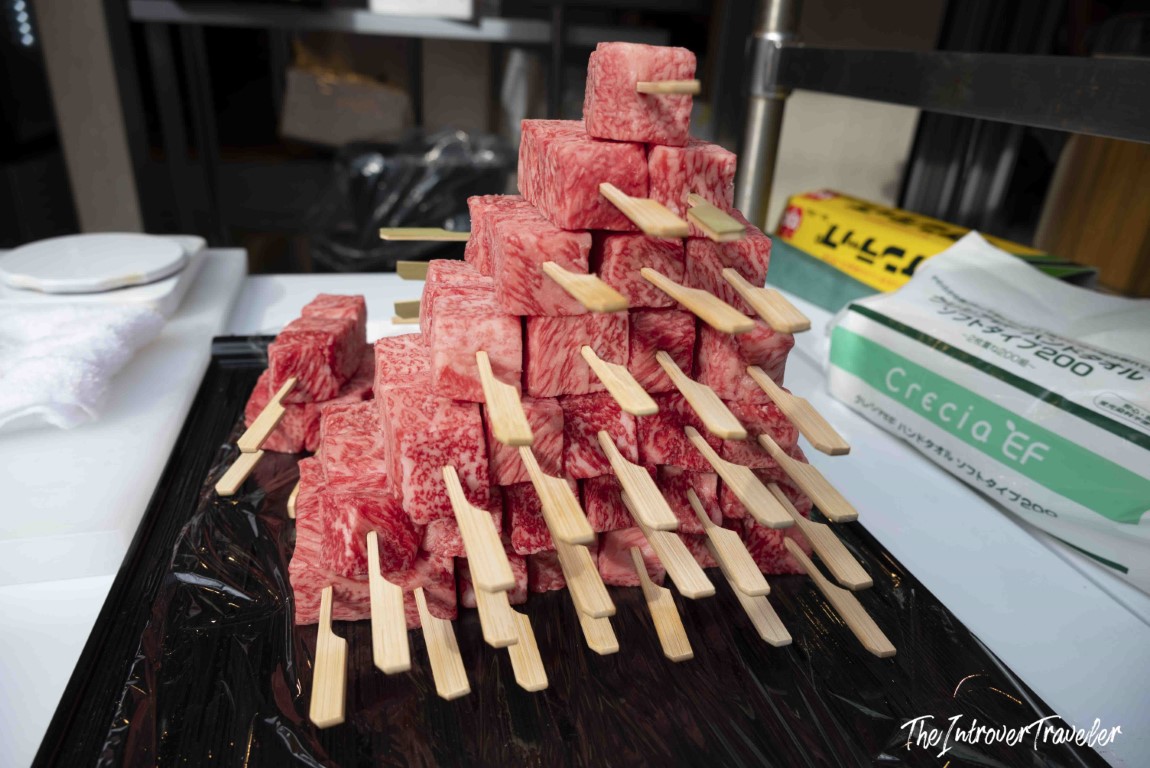 Pyramid of heavily marbled wagyu beef skewers stacked on a tray at Tsukiji market, Tokyo