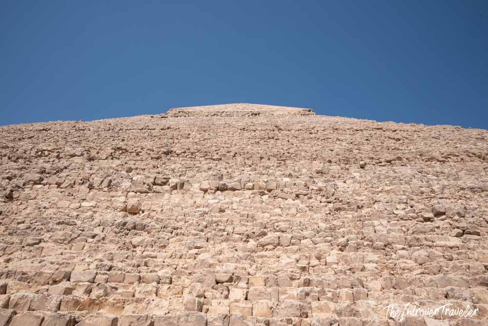 Close-up view looking up the massive limestone blocks of the Great Pyramid of Giza toward its apex