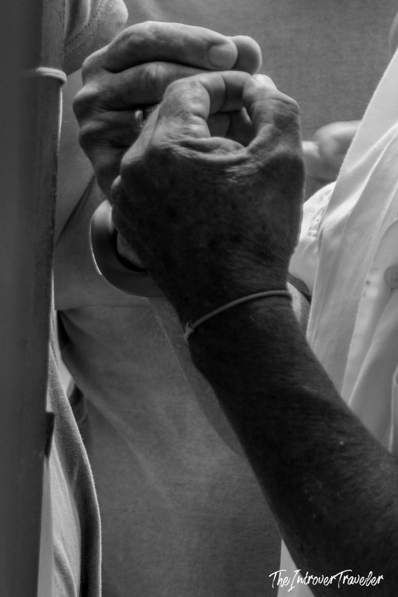 Close-up of clasped hands of a man in Mazara del Vallo, Sicily, black and white street portrait