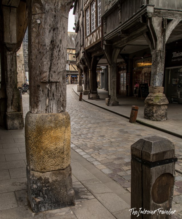 Cobblestone arcade street in Dinan with ancient timber columns on stone bases