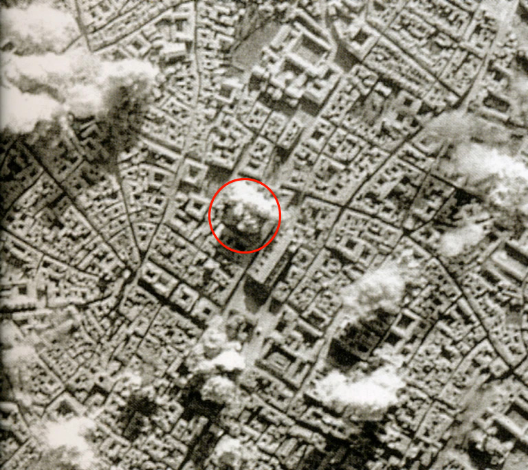 WWII aerial bombing photo of Bologna city center, with Archiginnasio Palace circled in red