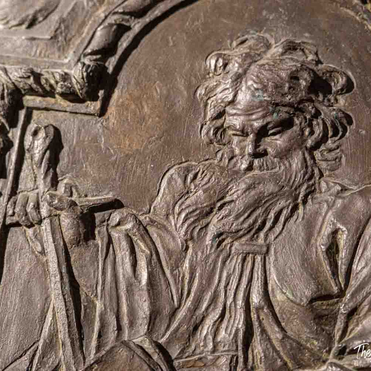 Close-up of a bronze relief detail showing a bearded figure, part of the Bernini Barberini exhibition in Rome