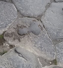 Ancient phallic symbol carved into the stone street pavement of Pompeii