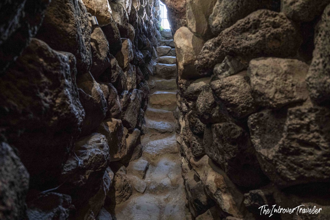 Narrow stone staircase inside Nuraghe Su Nuraxi at Barumini, flanked by ancient dry-stone walls