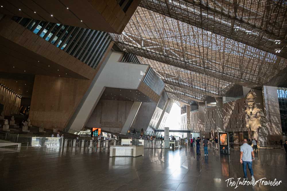 Grand Egyptian Museum atrium with colossal Ramses II statue and dramatic latticed ceiling, Cairo