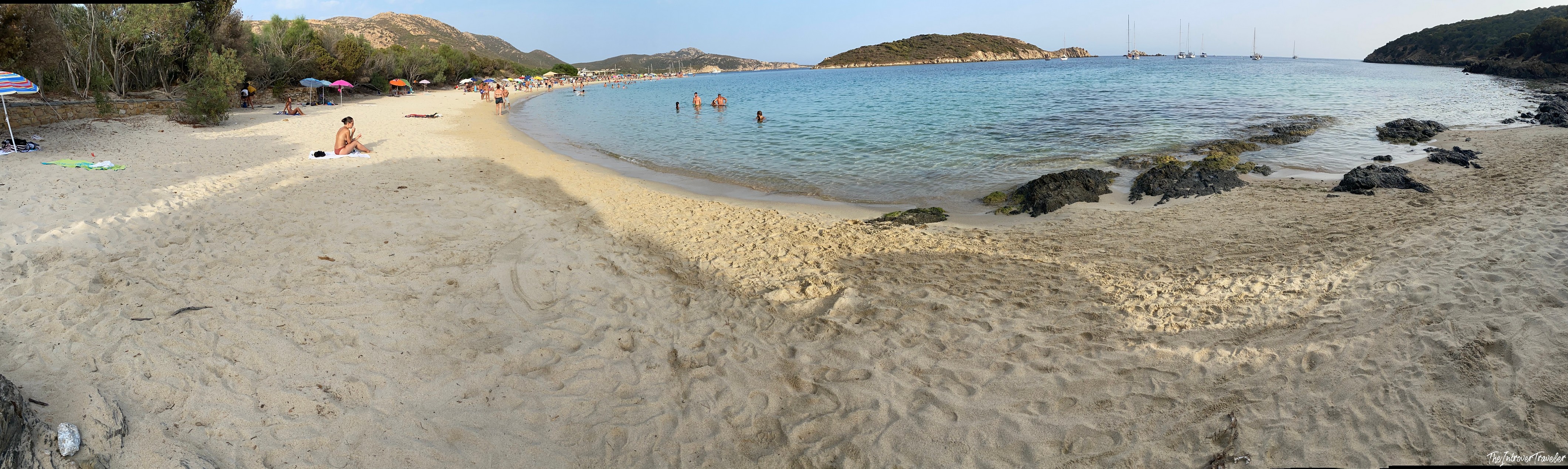 Panoramic view of a sheltered south Sardinia beach cove with turquoise water and golden sand