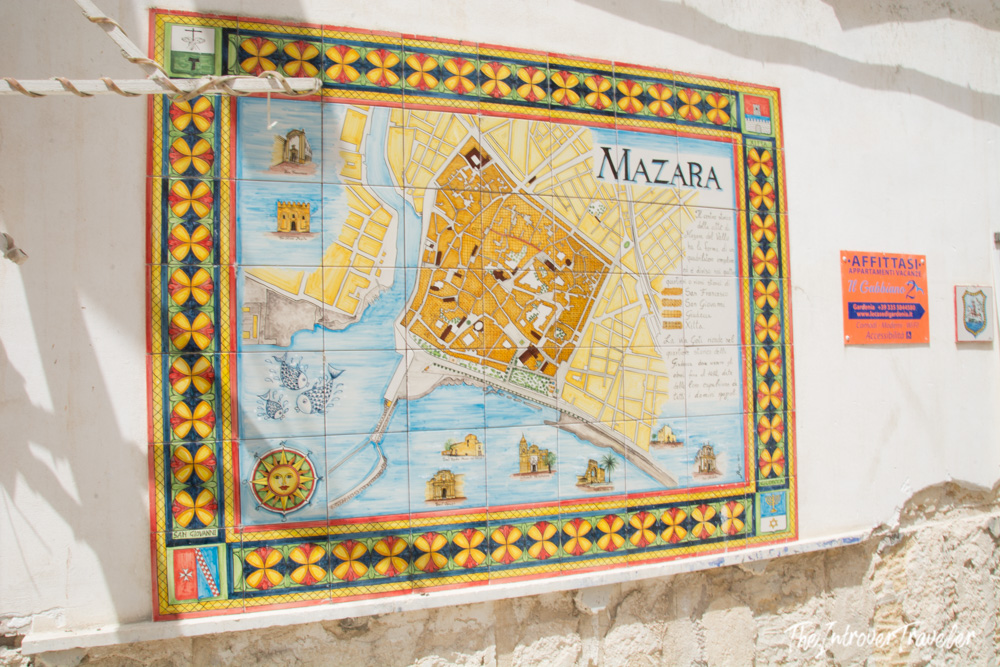 Colorful hand-painted ceramic tile map of Mazara del Vallo displayed on a whitewashed wall in Sicily