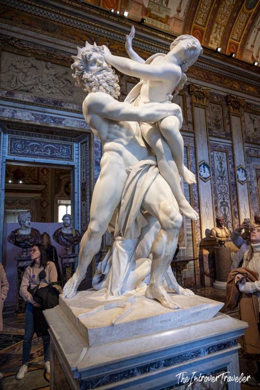 Bernini's Pluto and Proserpina marble sculpture at the Borghese Gallery, Rome, with visitors admiring it