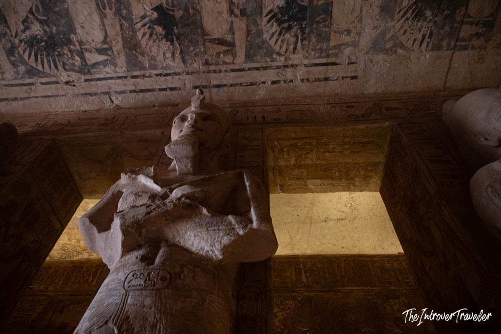 Ramesses II Osirid pillar statue inside Abu Simbel temple, with painted ceiling and hieroglyphs