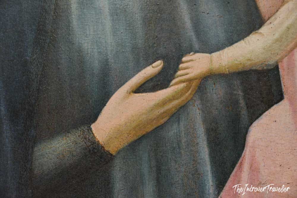 Close-up detail of two hands touching in a Botticelli painting at the Uffizi Gallery, Florence