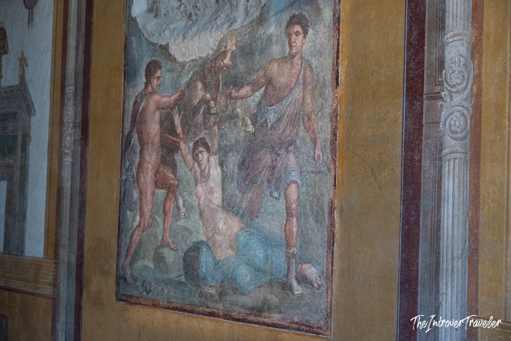 Ancient Roman mythological fresco on a ochre wall in a Pompeii house, showing figures in vivid colors