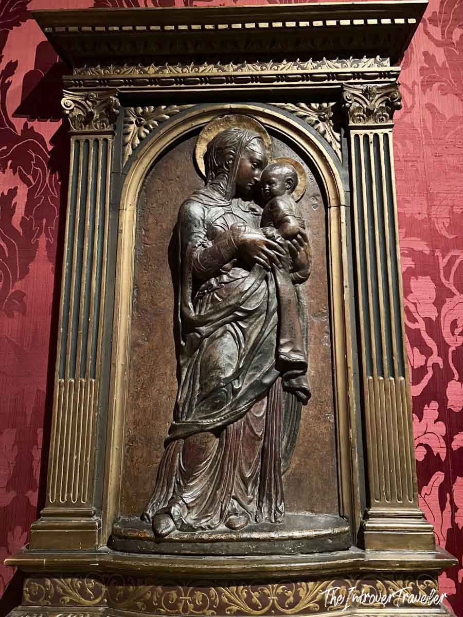 Bronze Madonna and Child relief sculpture in an ornate architectural frame at the Morgan Library, New York