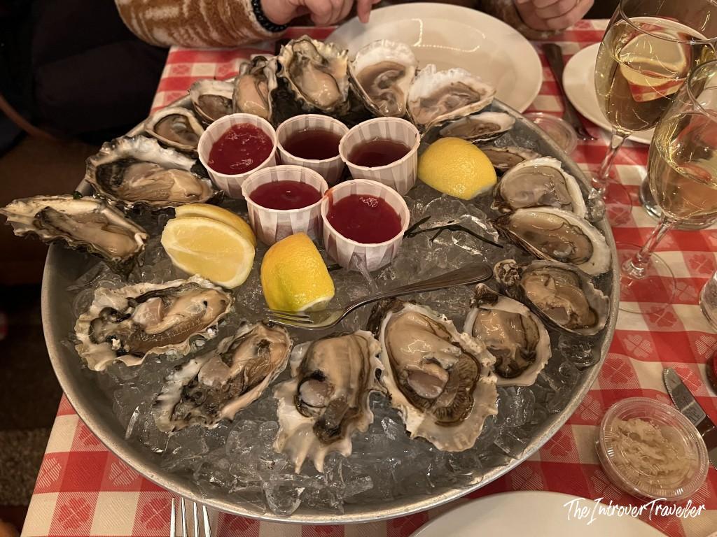 Platter of fresh raw oysters on ice with mignonette and lemon at Grand Central Oyster Bar, New York