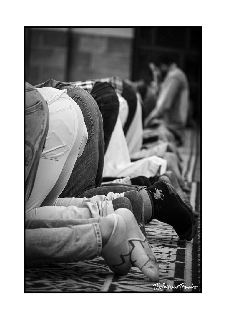Men bowing in prayer at a mosque in Egypt, captured in black and white street photography