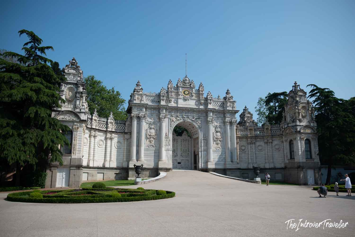 Ornate main gate of Dolmabahce Palace in Istanbul, with baroque carvings and manicured gardens