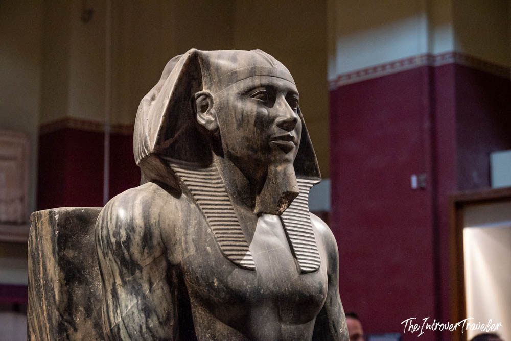 Ancient Egyptian pharaoh statue with nemes headdress on display at the Egyptian Museum in Cairo