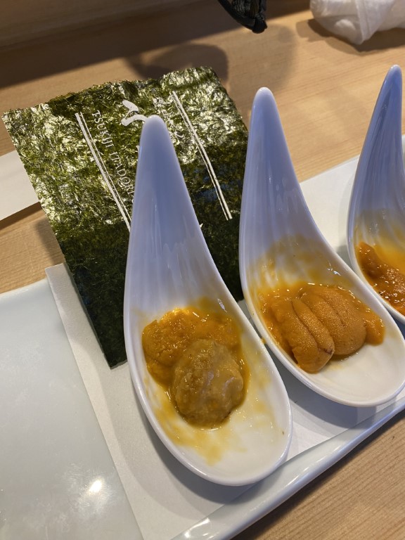Fresh uni sea urchin served on teardrop spoons with nori at Tsukiji fish market Tokyo