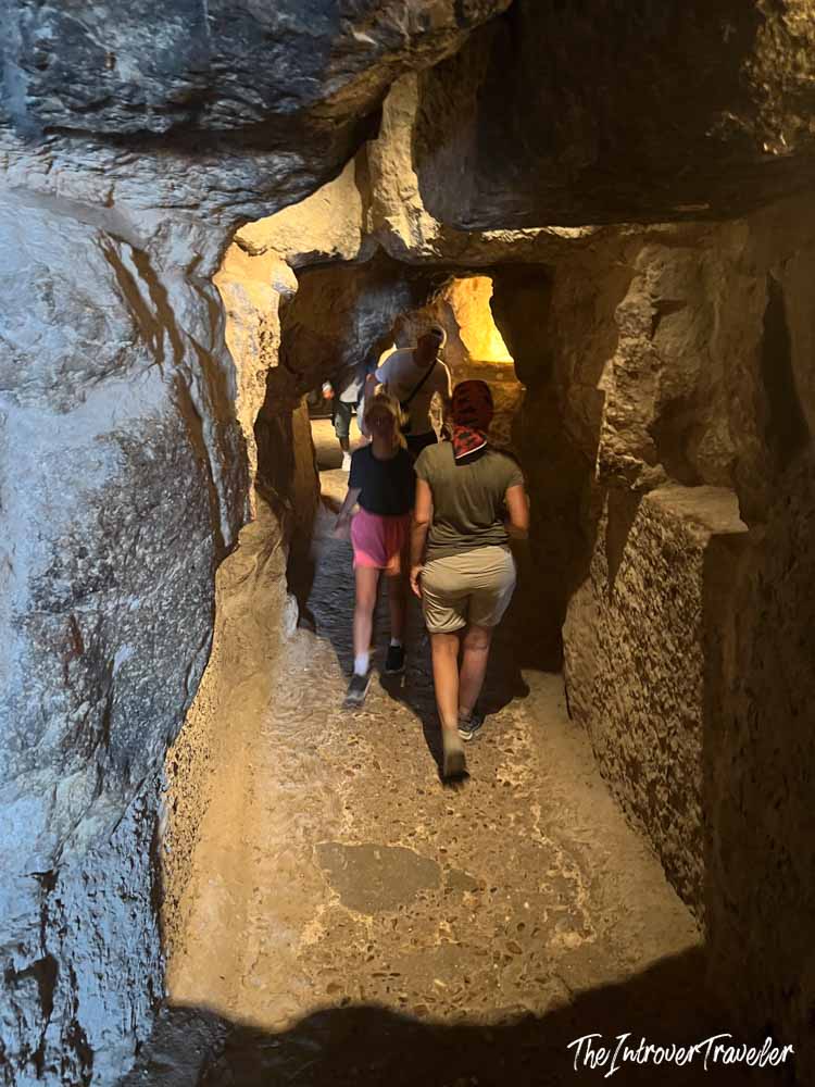 Tourists walking through a narrow ancient passage inside the Pyramids of Giza complex