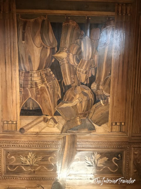 Intarsia panel in the Studiolo of Federico da Montefeltro depicting armor and weapons in trompe-l'oeil perspective