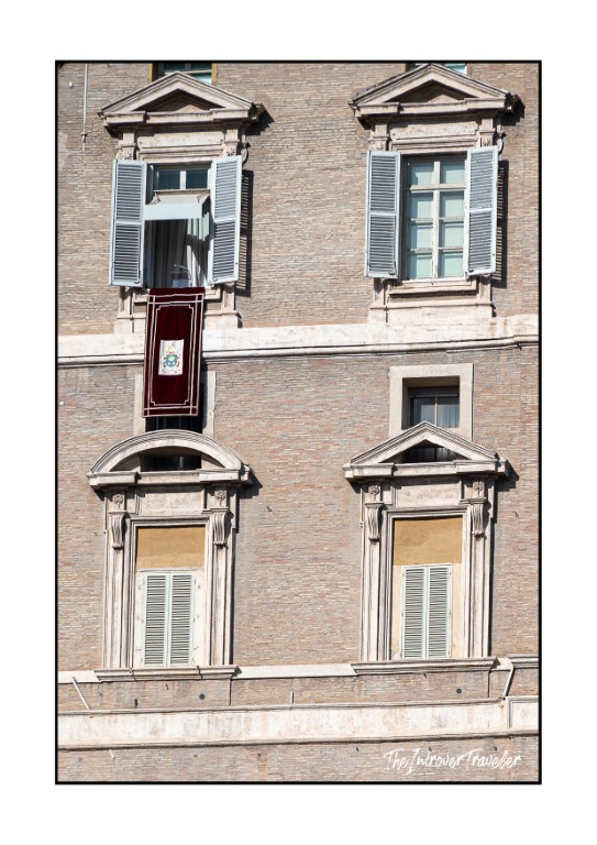 Papal apartments facade at the Vatican with red papal banner hanging from the central window