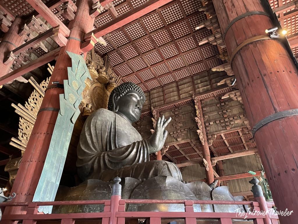 Giant bronze Daibutsu (Great Buddha) inside Todaiji Temple, Nara, with raised hand and ornate wooden hall