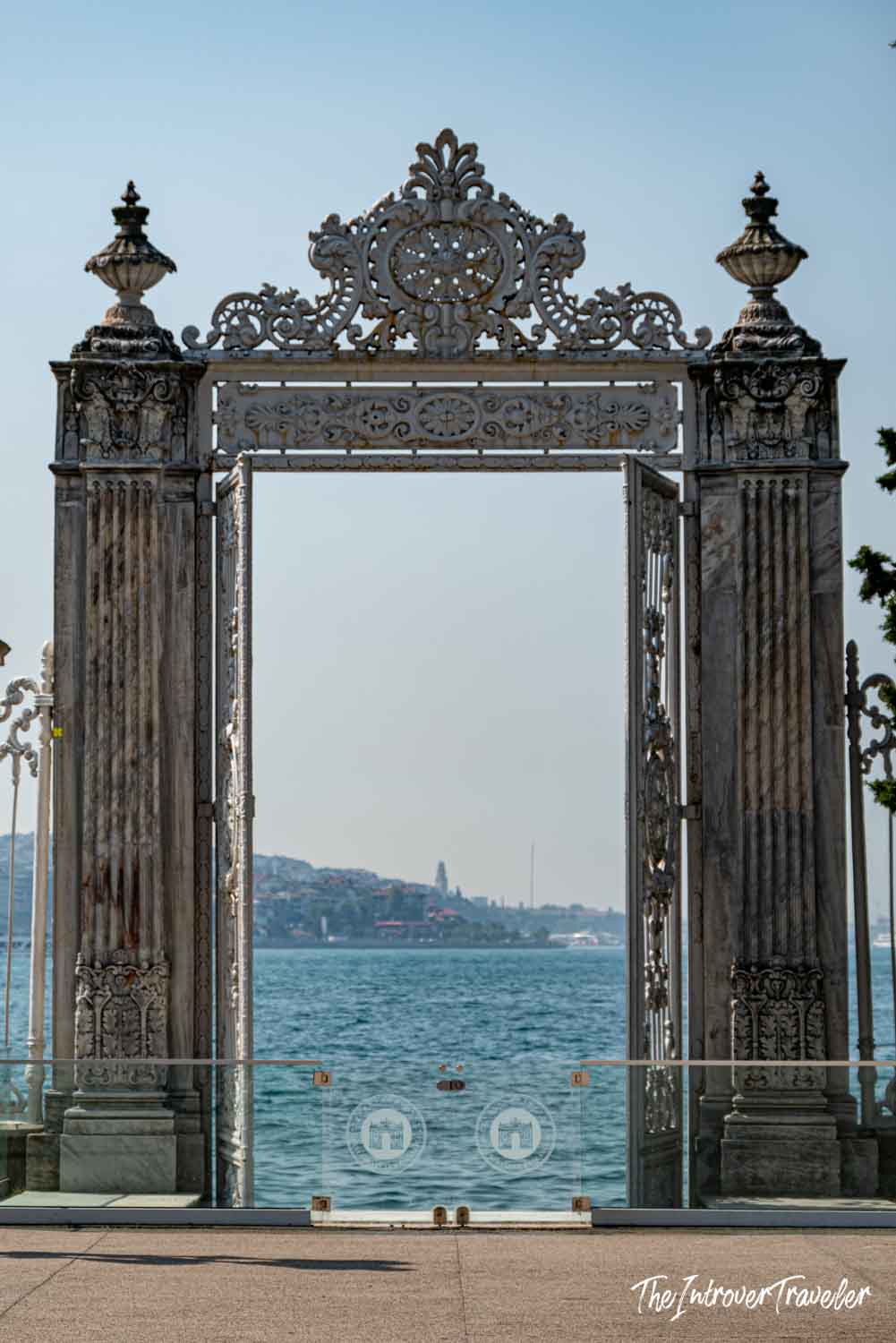 Ornate Bosphorus-facing gate of Dolmabahçe Palace framing views of the Istanbul strait