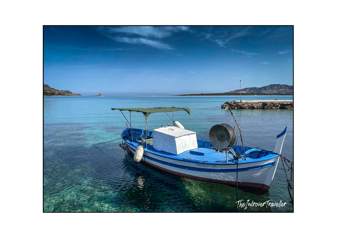 Blue and white fishing boat moored in turquoise waters near La Pelosa beach, Stintino, Sardinia