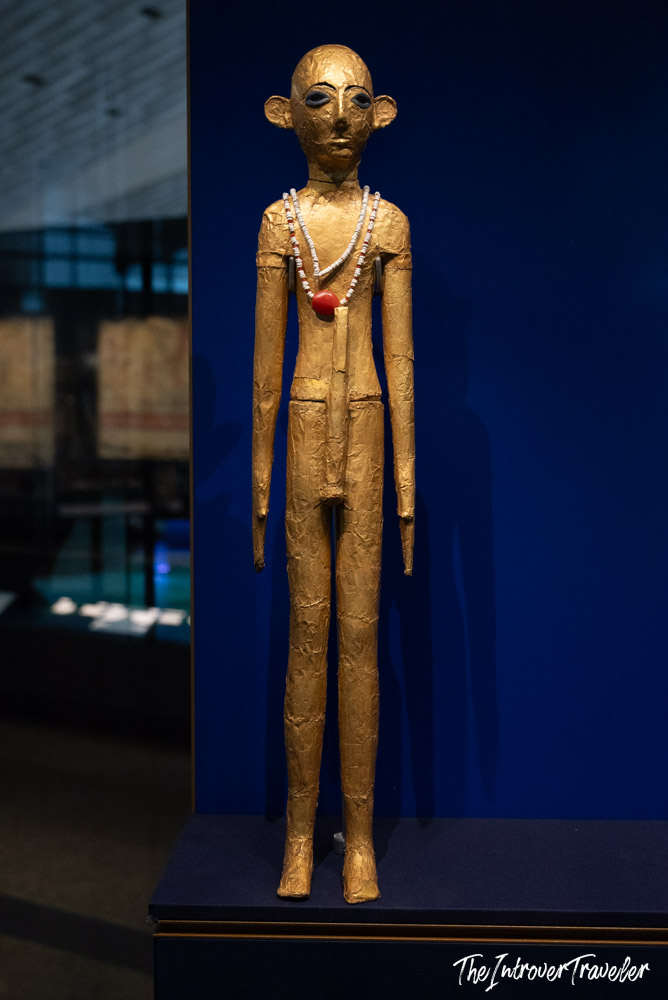 Ancient Egyptian gold-leafed figurine with bead necklace on display at the Grand Egyptian Museum, Cairo