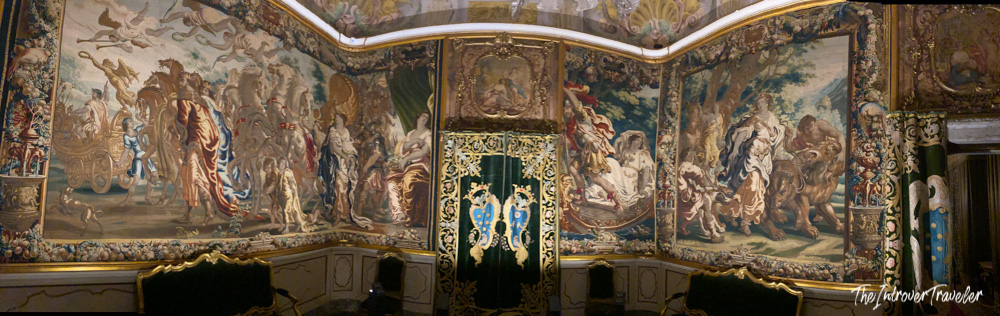 Baroque tapestry-lined private room inside Palazzo Pfanner, Lucca, with gilt door and mythological scenes