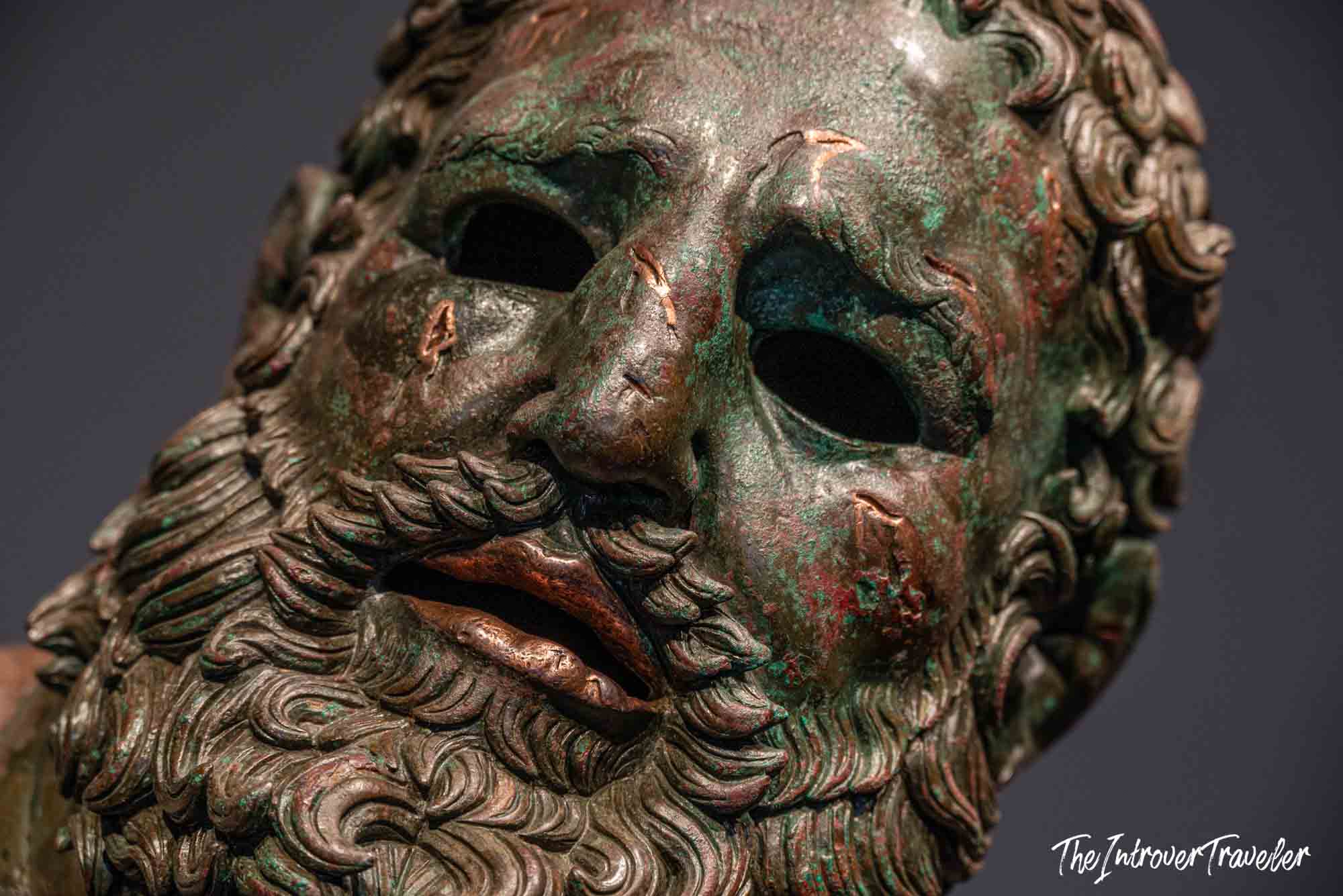 Close-up of the Boxer at Rest bronze face, showing verdigris patina and hollow eyes at Palazzo Massimo, Rome
