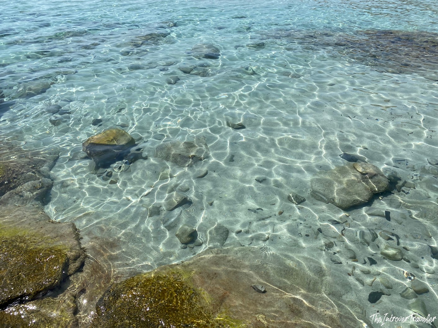 Crystal-clear shallow water over pebbles and sand at a south Sardinia beach shoreline