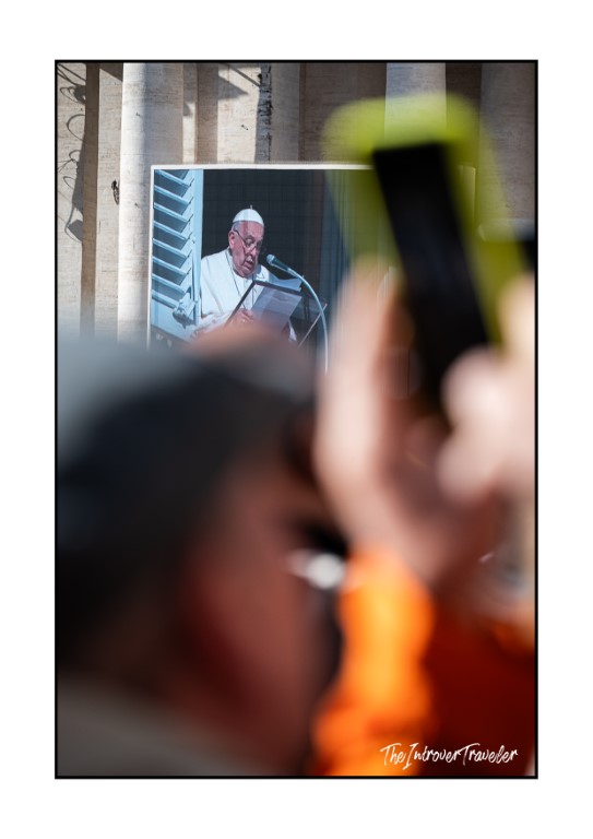 Pope Francis speaking at the Angelus, seen on a screen in St. Peter's Square, Vatican