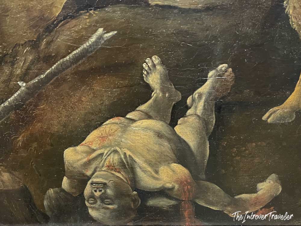 Close-up detail of a fallen warrior in a dramatic Baroque oil painting at the Met