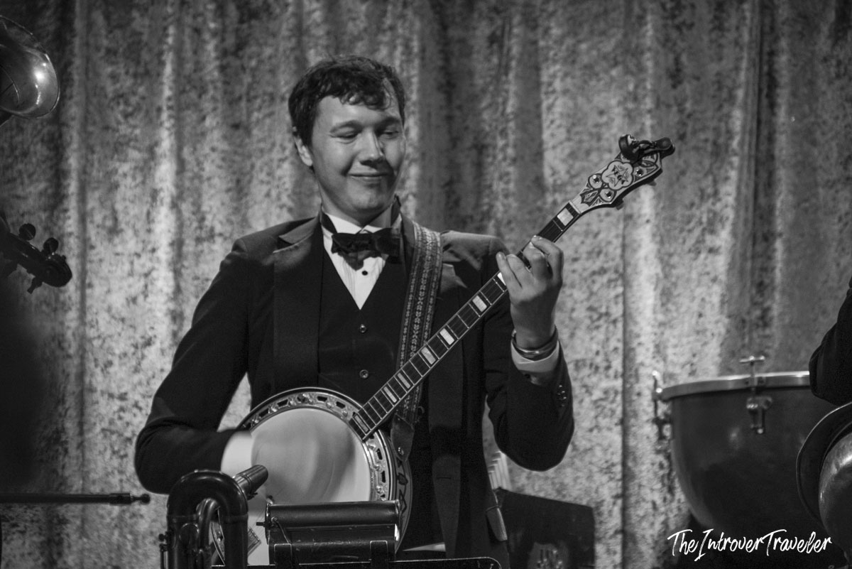Smiling banjo player in a tuxedo performing with Vince Giordano and the Nighthawks at Birdland, New York