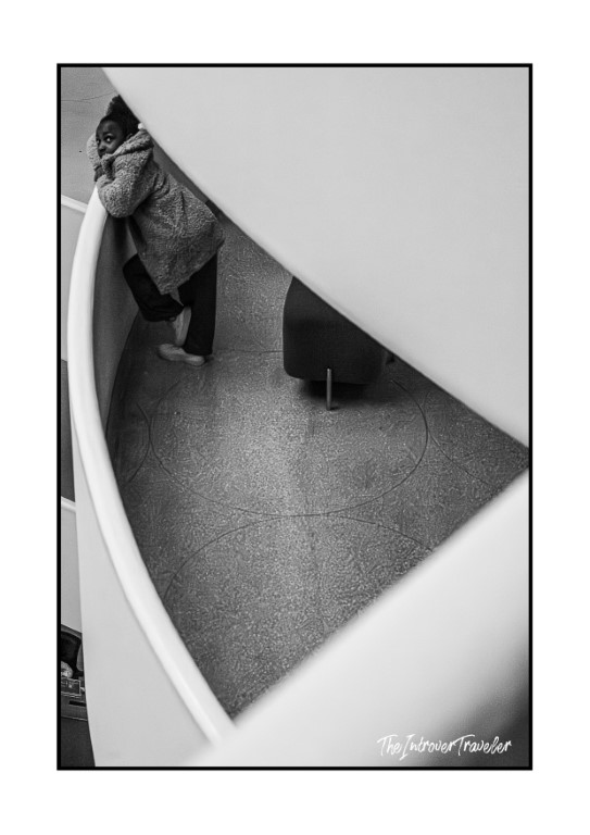 View from above of the Guggenheim Museum rotunda ramp, with a visitor looking up from the spiral floor below