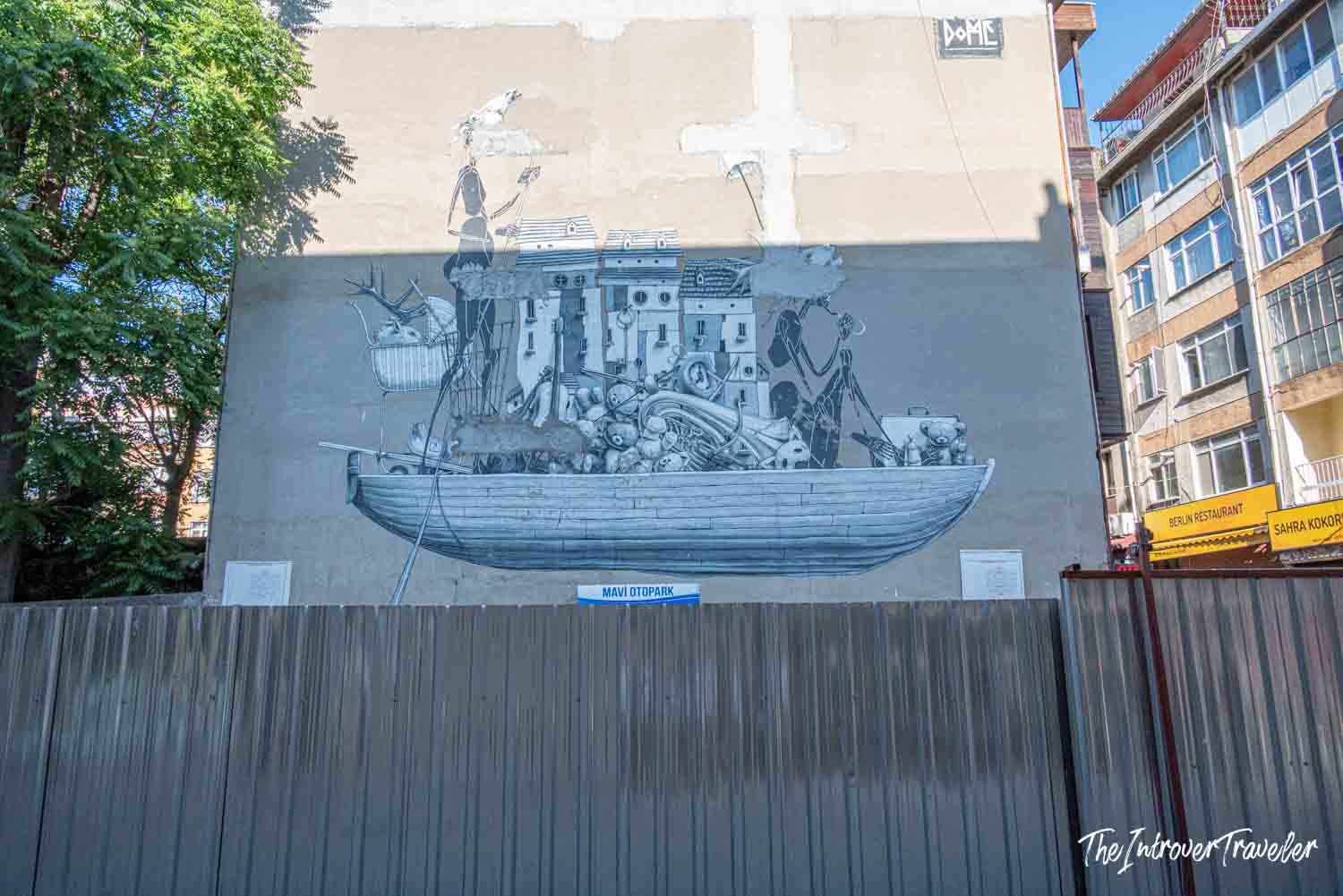 Black and white mural by Dome showing an overloaded boat with buildings, Kadıköy street art, Istanbul
