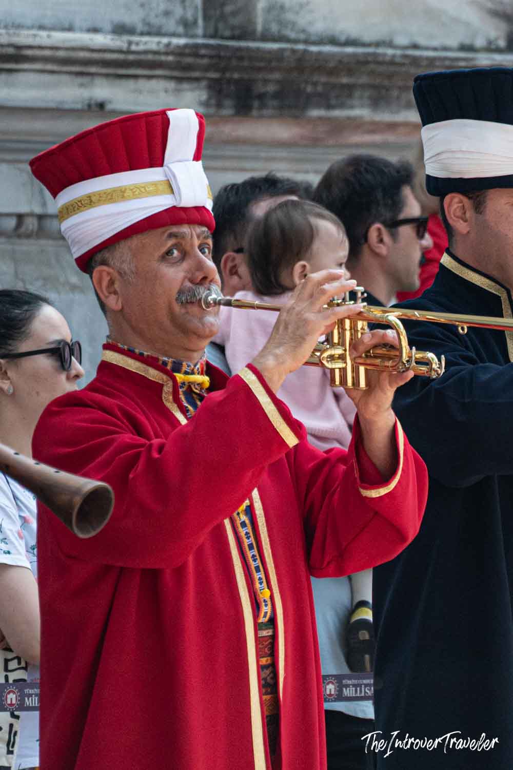 Ottoman Mehter band musician playing trumpet in traditional red uniform near Dolmabahce Palace, Istanbul
