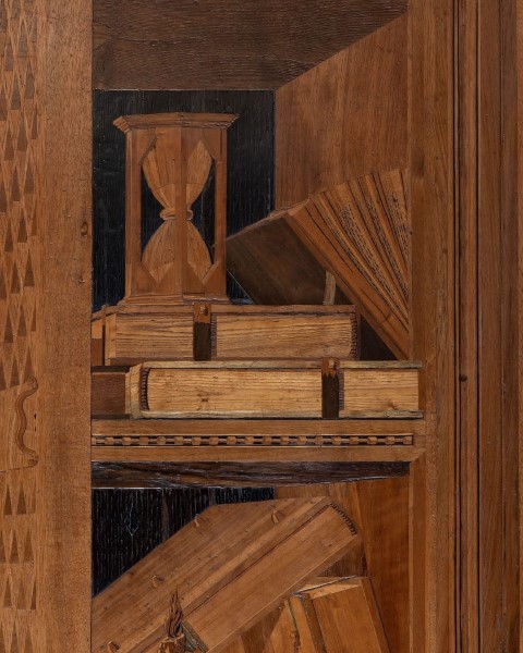 Intarsia detail in the Studiolo of Federico da Montefeltro showing hourglass, books, and folded fan