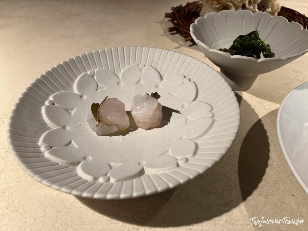 Delicate raw fish bites on a floral ceramic plate at Trattoria Da Lucio, Rimini