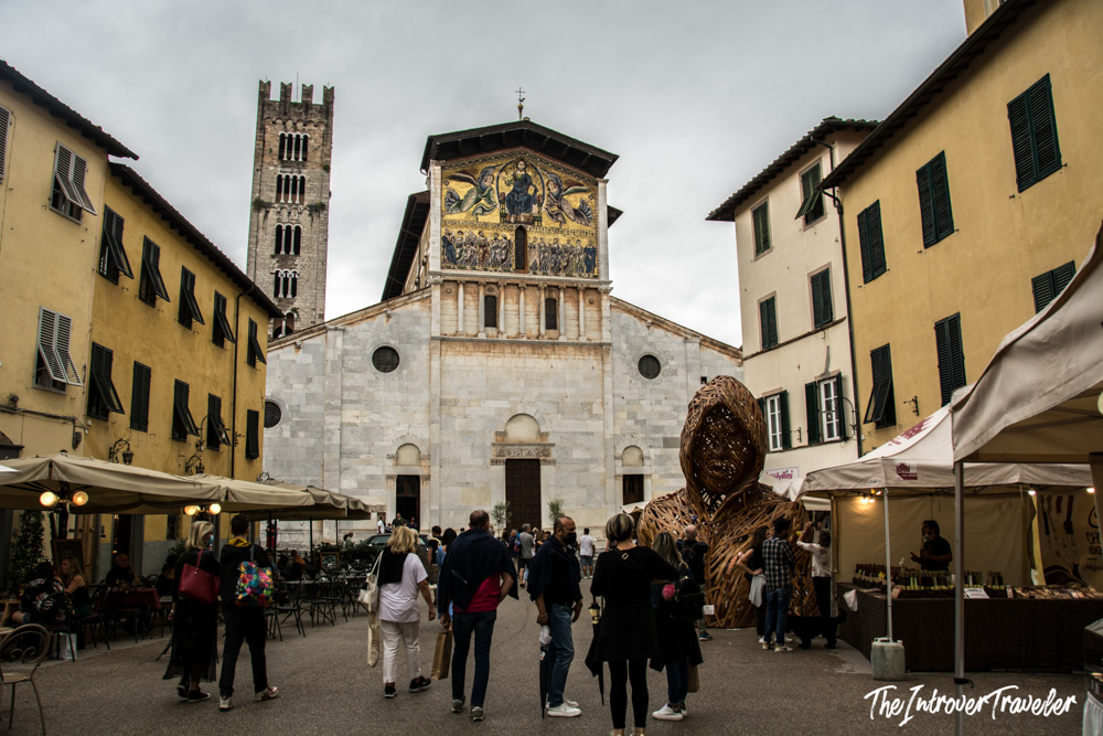 Basilica di San Frediano in Lucca, with its golden Byzantine mosaic facade and a busy street market below