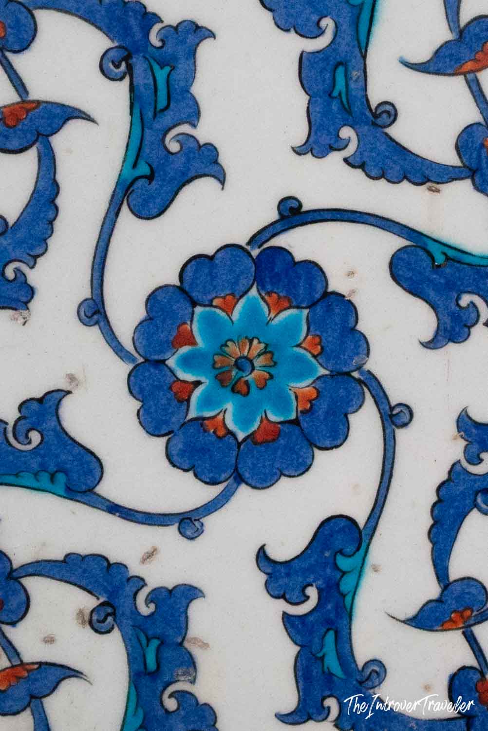 Close-up of Iznik tile floral pattern in blue and orange, decorating an Istanbul mosque interior